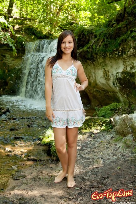 Голая девушка на фоне водопада. Фото.